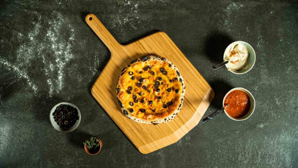 préparer une pizza maison : olive et houmous